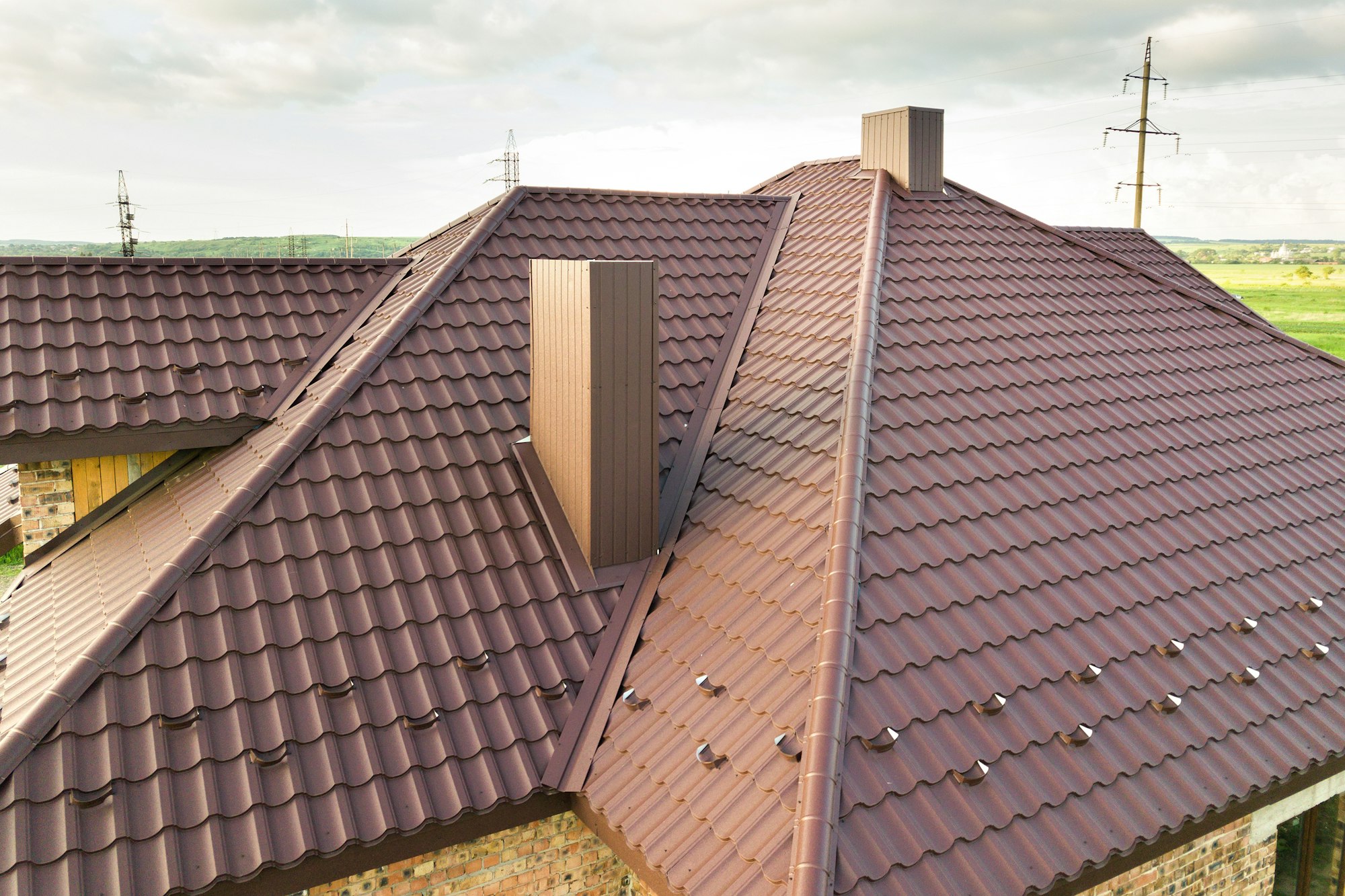 Detail view of house rooftop covered with brown metal tile sheets